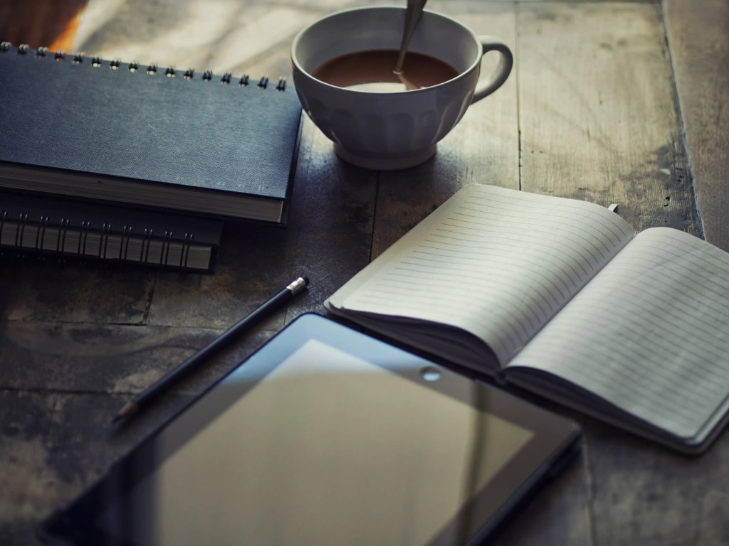 tasse de café, cahier et table de la nouvelle équipe de rédacteurs d'Aulnay Cap